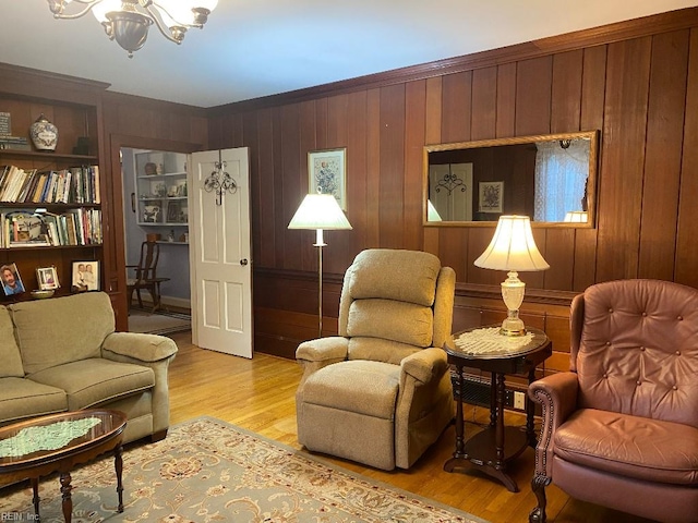 living room featuring a notable chandelier, wood walls, and light hardwood / wood-style flooring