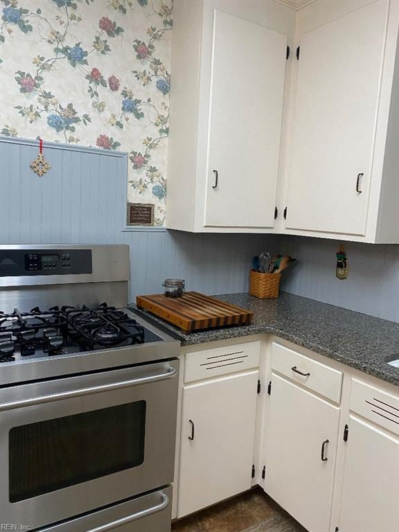 kitchen with stainless steel range with gas stovetop and white cabinetry