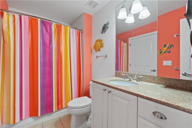 bathroom with an inviting chandelier, vanity, tile floors, and toilet