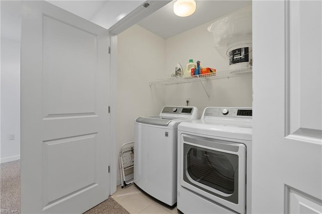 laundry area with separate washer and dryer and light tile floors