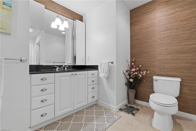 bathroom with toilet, tile flooring, and vanity