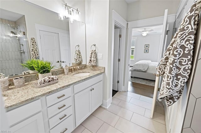 bathroom with ceiling fan, tiled shower, tile floors, and vanity with extensive cabinet space