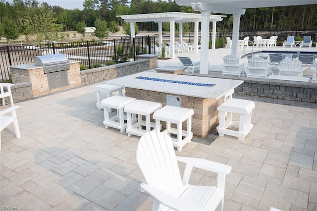 view of terrace with a pergola, an outdoor kitchen, area for grilling, and an outdoor bar