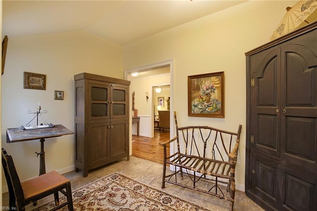 living area featuring light hardwood / wood-style floors and vaulted ceiling