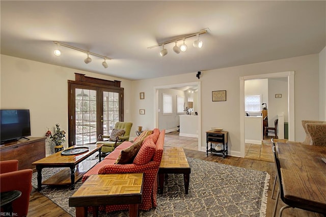 living room featuring french doors, dark tile floors, and track lighting