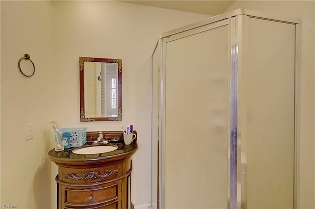 bathroom featuring a shower with door and vanity