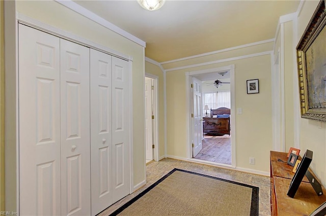 entryway with crown molding, ceiling fan, and light hardwood / wood-style flooring