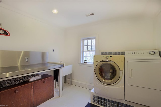 laundry room with light tile floors and separate washer and dryer