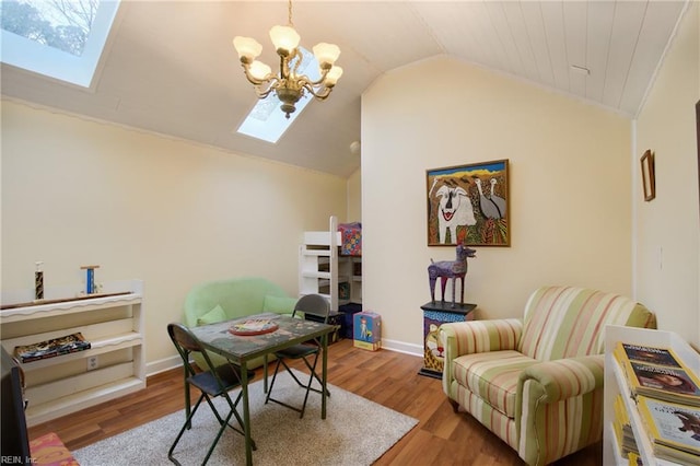 office space featuring light hardwood / wood-style floors, vaulted ceiling with skylight, and an inviting chandelier