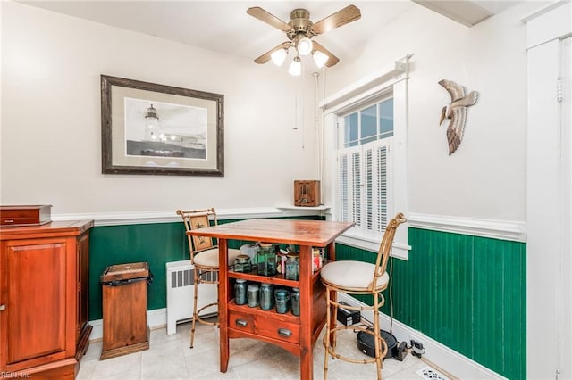 dining room featuring ceiling fan, radiator, and light tile floors