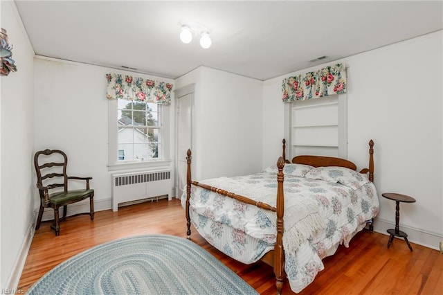 bedroom featuring light hardwood / wood-style floors and radiator