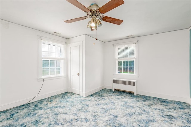 spare room with radiator heating unit and ceiling fan