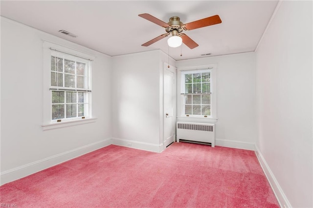 carpeted spare room with ceiling fan and radiator