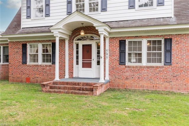 doorway to property with a lawn