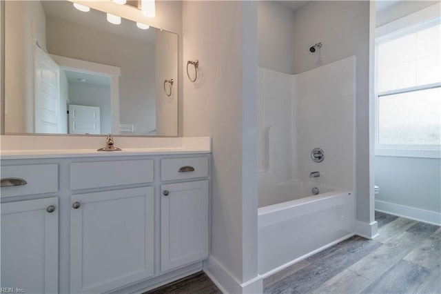 full bathroom featuring hardwood / wood-style floors, toilet, bathing tub / shower combination, and vanity