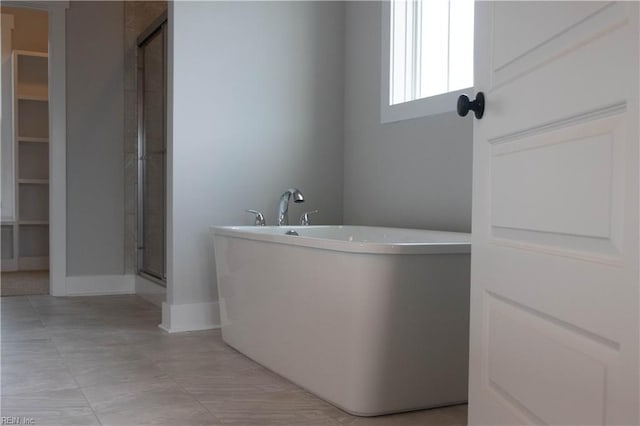 bathroom featuring a shower with shower door and tile floors