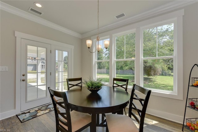 dining space featuring crown molding, a notable chandelier, a wealth of natural light, and light hardwood / wood-style floors