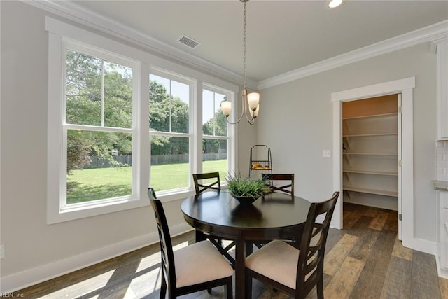 dining room featuring an inviting chandelier, ornamental molding, dark wood-type flooring, and a wealth of natural light