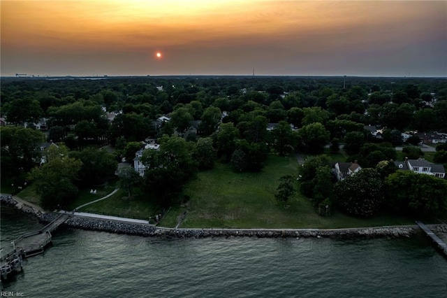 aerial view at dusk featuring a water view