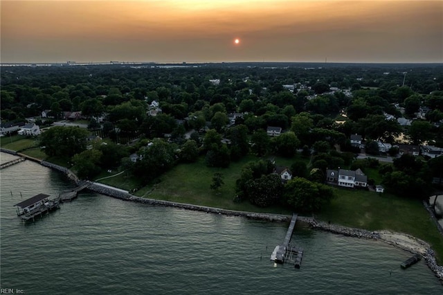 aerial view at dusk featuring a water view