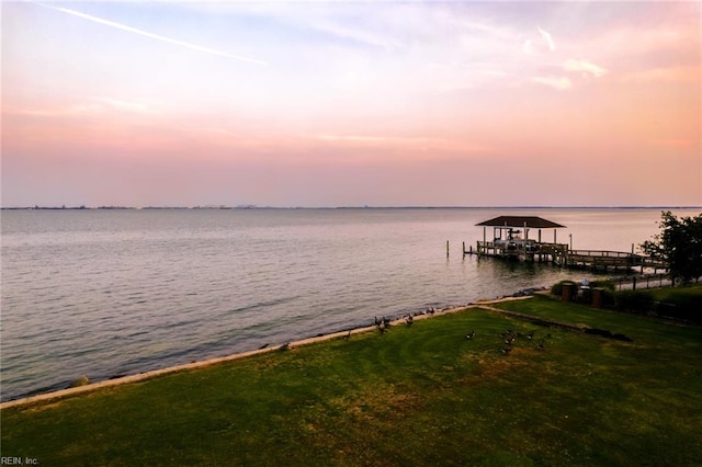 view of dock with a water view and a yard