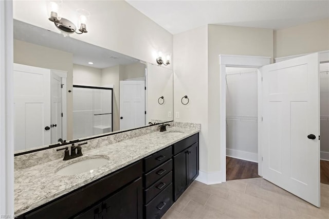 bathroom featuring an enclosed shower, tile floors, and dual bowl vanity