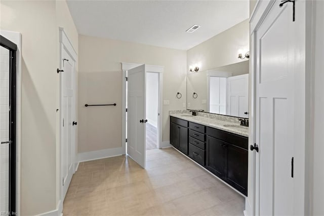 bathroom featuring tile floors and dual vanity