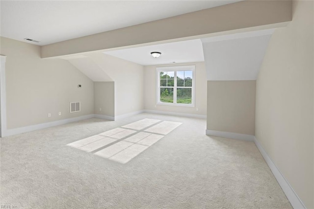 additional living space featuring light colored carpet and vaulted ceiling with beams