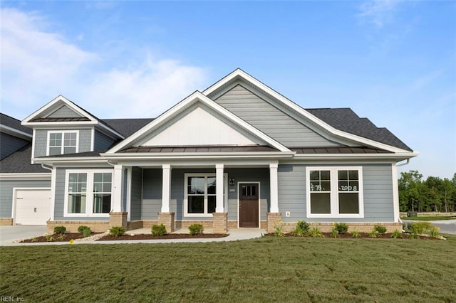 craftsman house with a porch, a garage, and a front yard