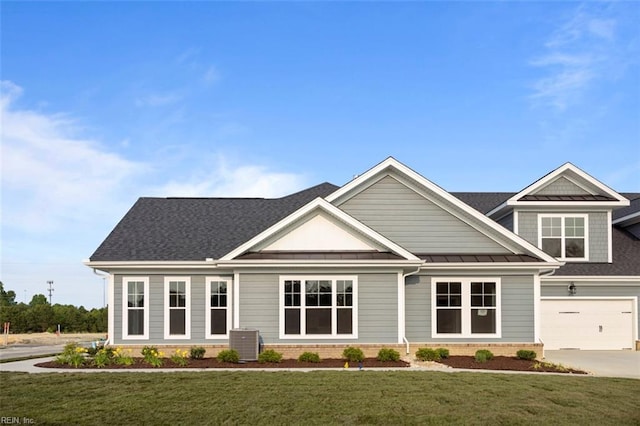 craftsman inspired home with a garage, central AC unit, and a front yard