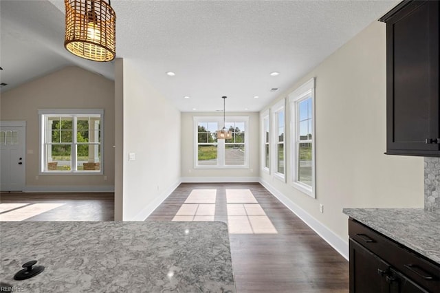 unfurnished living room featuring a healthy amount of sunlight, light hardwood / wood-style flooring, and lofted ceiling