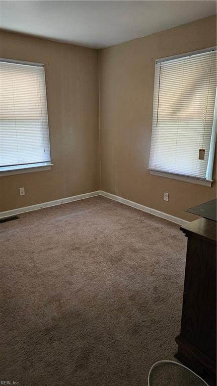 carpeted empty room with a healthy amount of sunlight