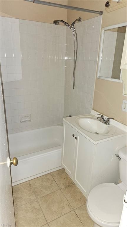 full bathroom with tile flooring, tiled shower / bath, vanity, and toilet