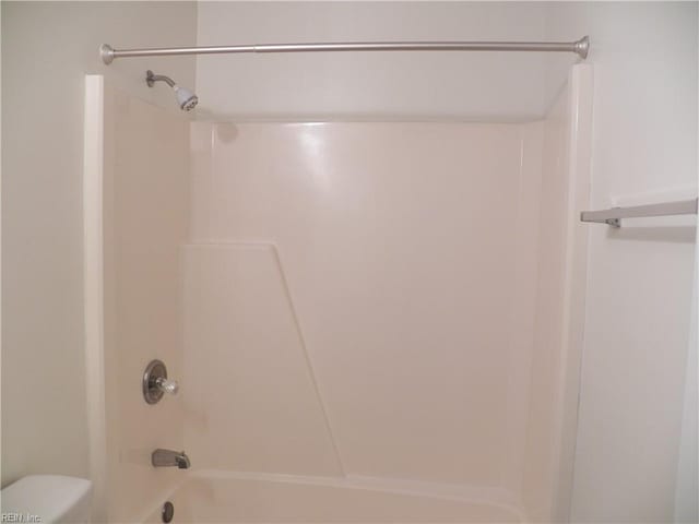 bathroom with shower / washtub combination and toilet