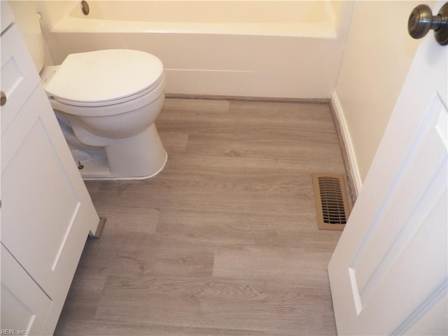 bathroom with wood-type flooring and toilet