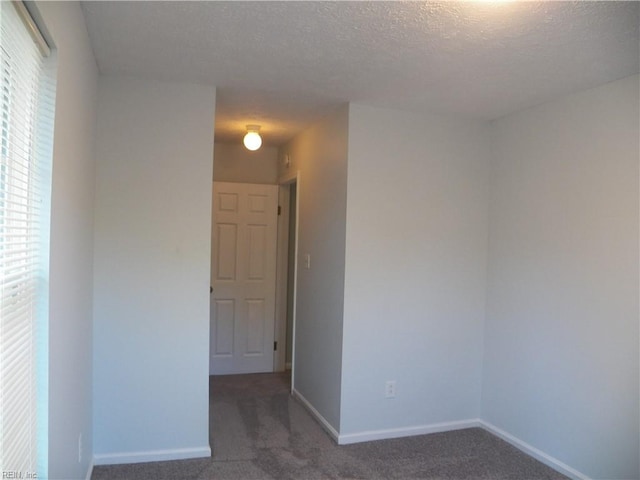 carpeted spare room with a textured ceiling