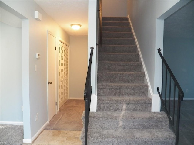 stairs featuring carpet flooring