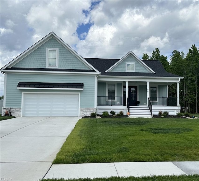 view of front of property featuring covered porch, a garage, and a front lawn