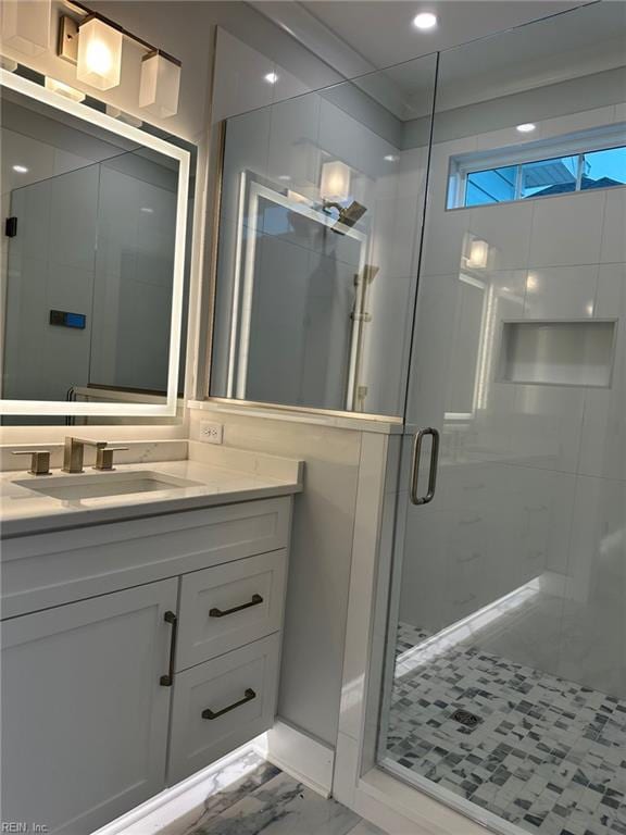 bathroom featuring vanity and a shower with door