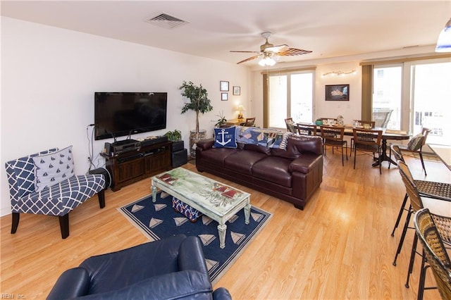 living room with light hardwood / wood-style floors and ceiling fan