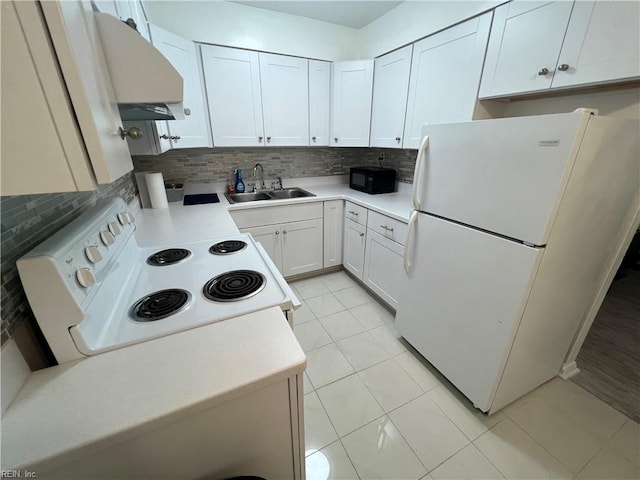 kitchen with white refrigerator, wall chimney range hood, stove, white cabinetry, and light tile floors