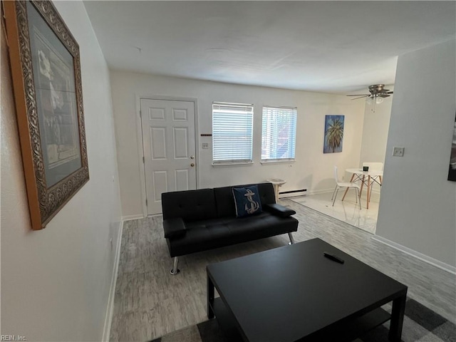 living room featuring baseboard heating, ceiling fan, and hardwood / wood-style flooring