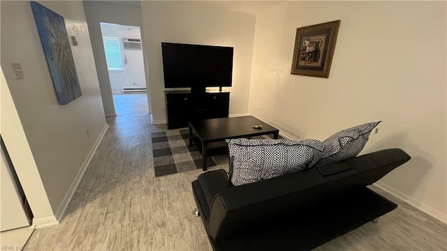 living room with a baseboard heating unit and wood-type flooring