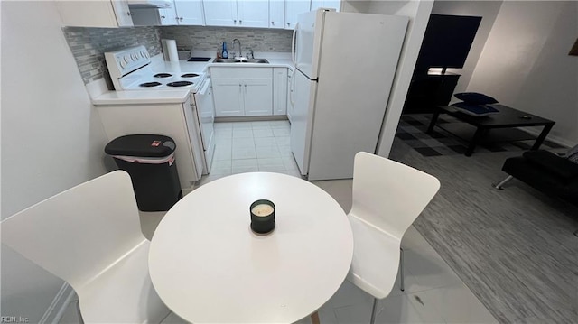 kitchen featuring tasteful backsplash, light tile flooring, white appliances, and white cabinetry