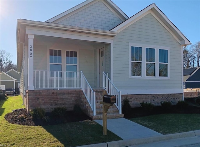 view of front of property featuring covered porch and a front lawn