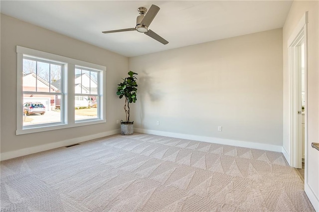 spare room featuring light colored carpet and ceiling fan