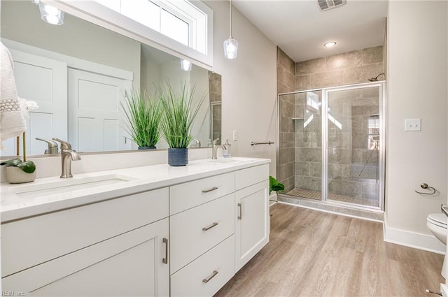 bathroom with vanity, wood-type flooring, an enclosed shower, and toilet