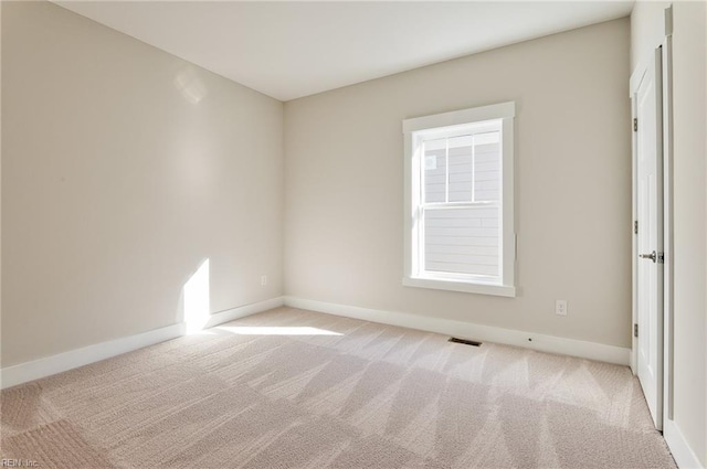 spare room featuring light carpet