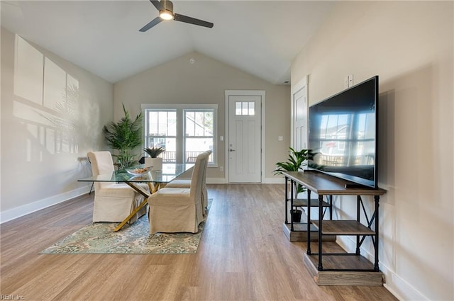 dining space with light hardwood / wood-style floors, high vaulted ceiling, and ceiling fan