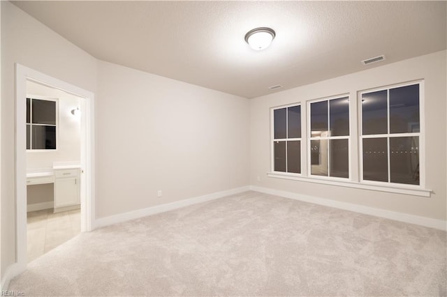 unfurnished room featuring light colored carpet